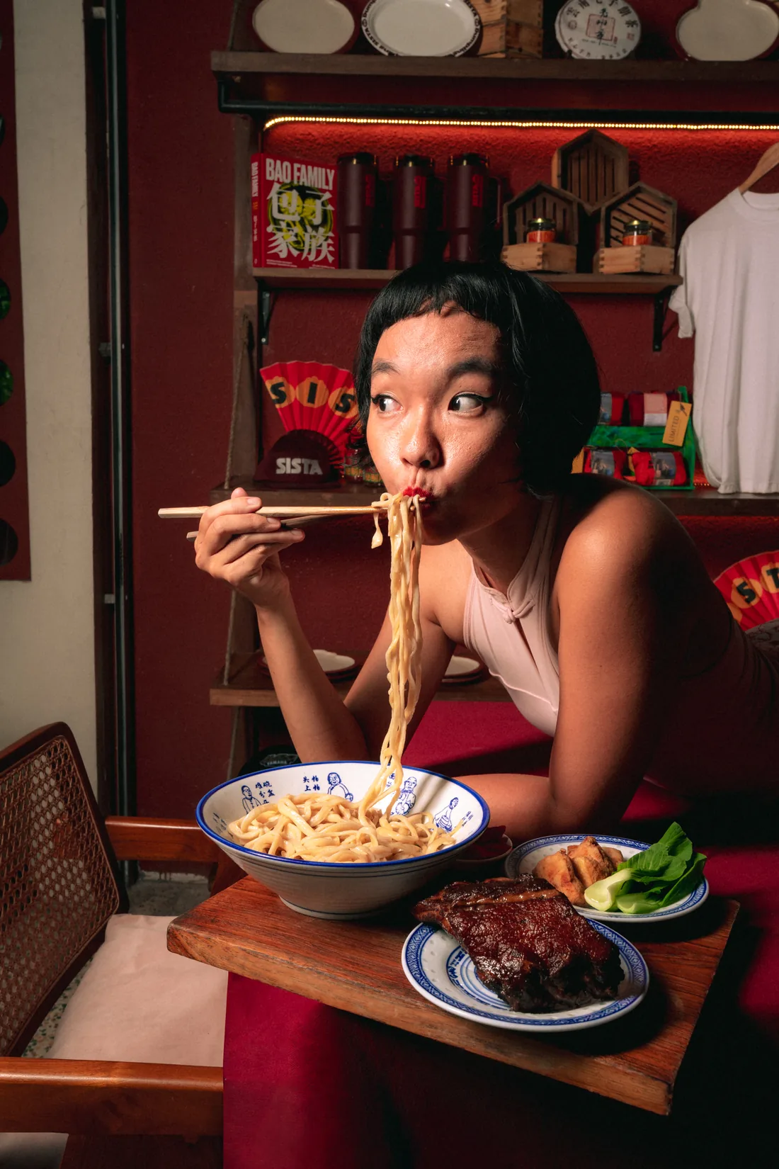 A guest slurping hand-pulled noodles in the dining room